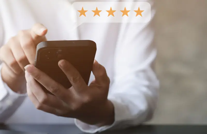 Persona comprobando las valoraciones de cinco estrellas de un profesional antes de contratarlo